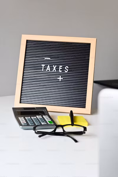A sign that says taxes next to a pair of glasses
